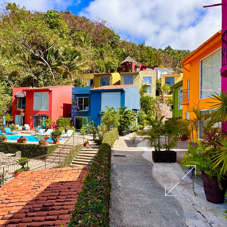 Female preparing for a yoga session indoors, holding a mat and water bottle.